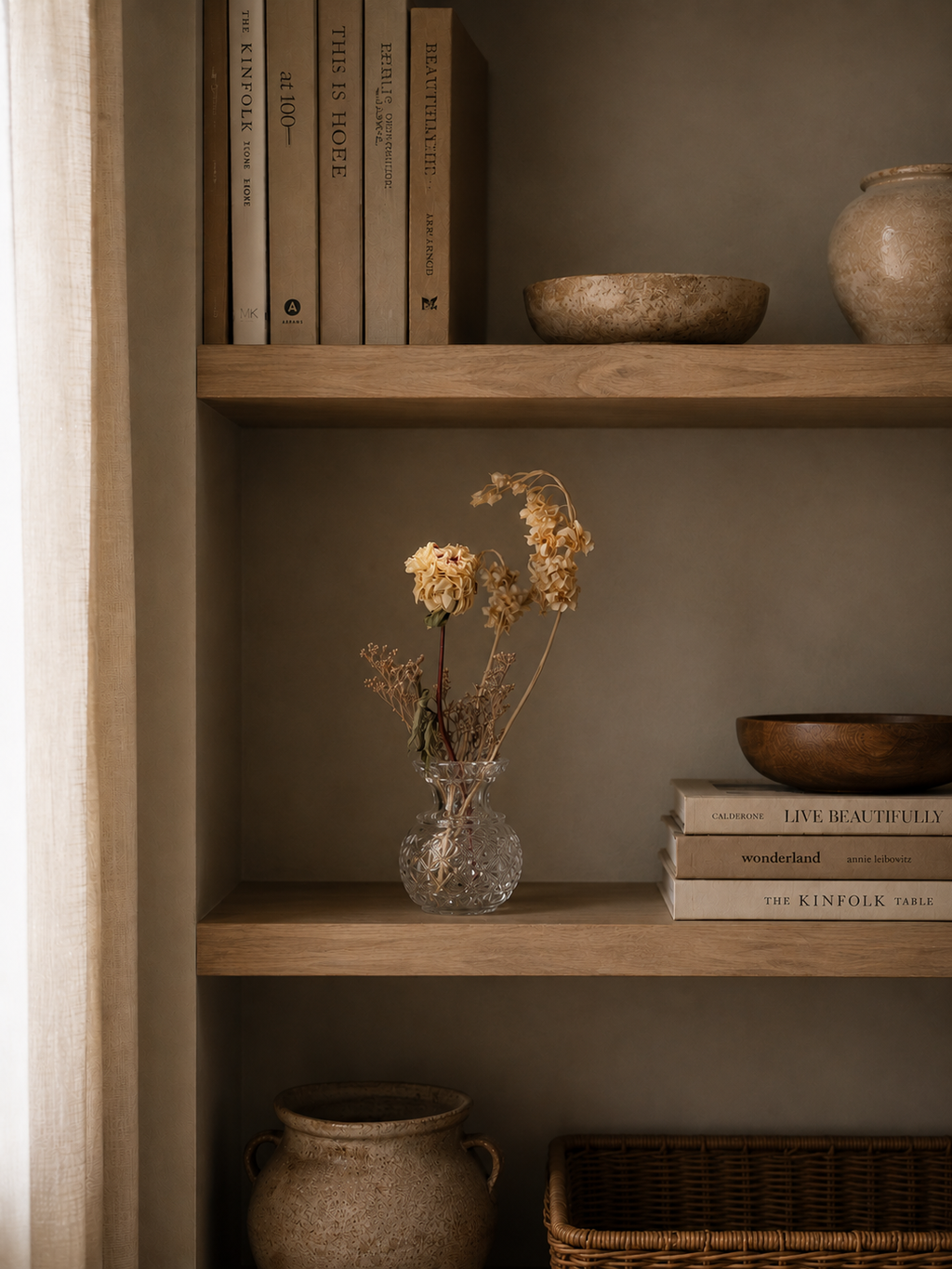 Overhead view of the crystal vase with dried peony and other flowers standing on a book shelf